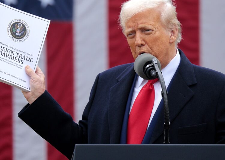 WASHINGTON, DC - APRIL 02: U.S. President Donald Trump holds up a copy of a 2025 National Trade Estimate Report as he speaks during a “Make America Wealthy Again” trade announcement event in the Rose Garden at the White House on April 2, 2025 in Washington, DC. Touting the event as “Liberation Day”, Trump is expected to announce additional tariffs targeting goods imported to the U.S. (Photo by Chip Somodevilla/Getty Images)