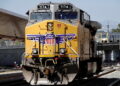 A GE AC4400CW diesel-electric locomotive in Union Pacific livery, is seen ahead of a possible strike if there is no deal with the rail worker unions, as a Metrolink commuter train (right) arrives at Union Station in Los Angeles, California, U.S., September 15, 2022. REUTERS/Bing Guan