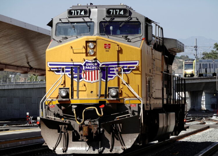 A GE AC4400CW diesel-electric locomotive in Union Pacific livery, is seen ahead of a possible strike if there is no deal with the rail worker unions, as a Metrolink commuter train (right) arrives at Union Station in Los Angeles, California, U.S., September 15, 2022. REUTERS/Bing Guan